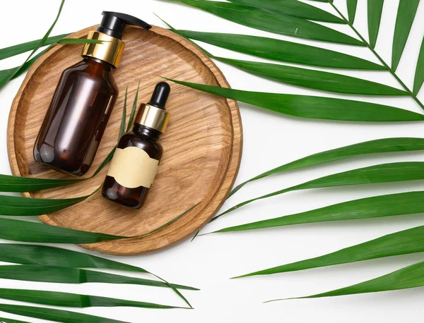 Kahverengi pipetli cam şişe kahverengi arka planda duruyor. Kozmetik, serum ve yağ konteynırı