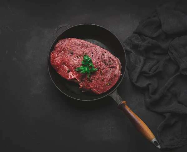 Rauwe Biefstuk Ligt Een Metalen Ronde Koekenpan Een Zwarte Tafel — Stockfoto