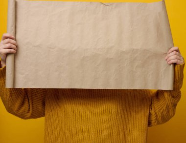 Kahverengi kraft kağıdının boş kahverengi paketini tutan kadın. Bir yazı, reklam ve bilgi için yer. Boşluğu kopyala