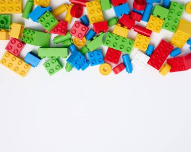Scattered parts of a plastic children's designer, top view. White background