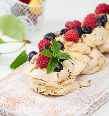 Taze böğürtlenlerle süslenmiş çırpılmış tavuk proteini ve kremadan yapılmış fırında kek. Tatlı Pavlova