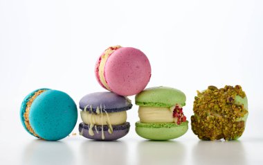 Beyaz arka planda badem unundan yapılmış yuvarlak Fransız kekleri. Ahududu, fıstık ve lavanta aromalı.