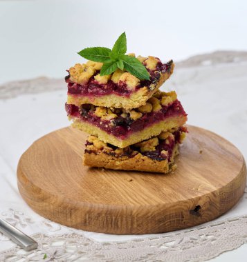 Kare dilimler halinde kiraz parçacıkları beyaz arkaplanda bir yığın halinde uzanır.