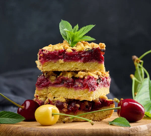 Kare dilimler halinde kiraz parçacıkları siyah bir arkaplanda duruyor.