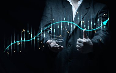 Siyah takım elbiseli bir adam, holografik grafiğin arka planında artan göstergelerle birlikte minyatür bir el arabası tutuyor. İş satışlarında artış, yüksek marjlar. Büyük kar