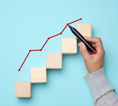 Büyüyen göstergeleri olan bir grafik ve mavi arka planda işaret olan bir kadın eli. Ticarette başarılı satış, enflasyon ve yükselen fiyatlar kavramı