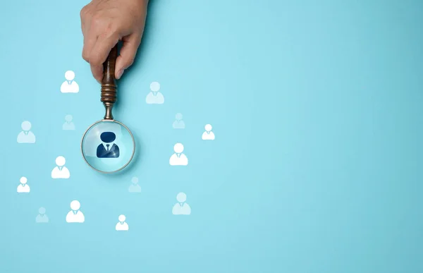 Search and selection of personnel in the company. Effective personnel management, leader identification. Magnifying glass and staff icons on blue background