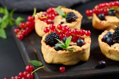 Round mini fruit pie on a wooden board