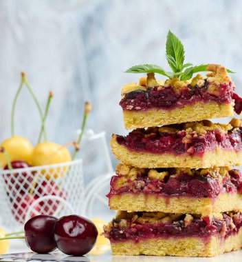 Kare dilimler halinde kiraz parçacıkları beyaz bir tahtanın üzerinde duruyor, yaz tatlısı.