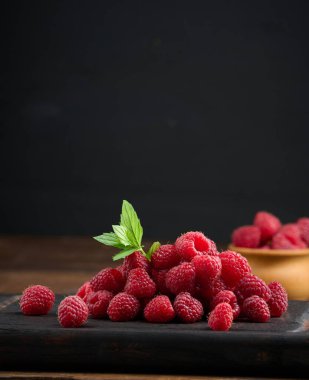 Kahverengi tahta üzerinde olgun kırmızı ahududular