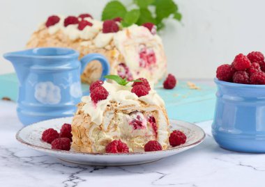 Baked meringue roll with cream and fresh red raspberry, white background	