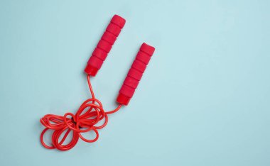 Kırmızı spor atlama ipi mavi arka planda, üst manzara