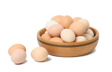 Beyaz izole edilmiş arka planda, tahta bir tabakta çiğ kahverengi ve beyaz tavuk yumurtaları.