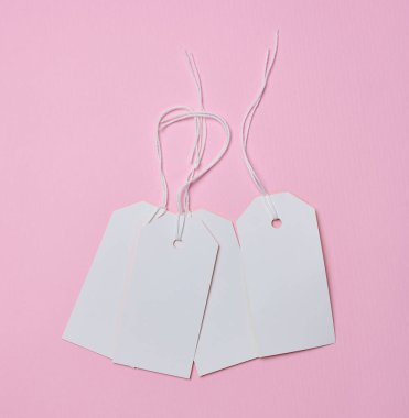 Beyaz ipte beyaz karton etiket, pembe arka plan. Fiyat etiketi şablonu