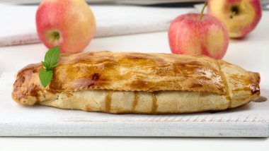 Elma tozu serpiştirilmiş, beyaz tahta üzerine pudra şekeri serpiştirilmiş turta, lezzetli bir tatlı.