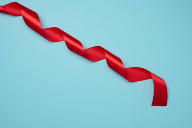 Mavi zemin üzerindeki süsleme için bükülmüş ipek kırmızı kurdeleler, üst görünüm