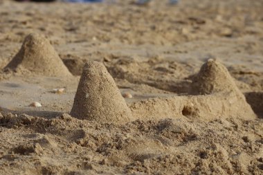 Dubai sahilindeki kumdan kalelere yakın çekim, kısmen bulanık.