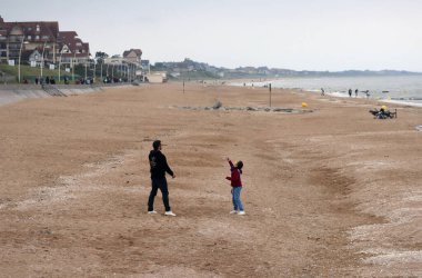 Cabourg, Fransa - 06.06.2022: Baba ve kızı Cabourg sahilinde uçurtma uçuruyorlar