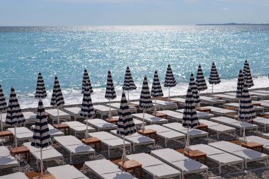Nice 'te, Akdeniz kıyılarında güneş panjurları ve kapalı güneş şemsiyeleri olan sahili görmek.