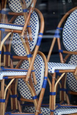 Kapalı bir restoranın vitrininde sandalyeler üst üste dizilmiş.