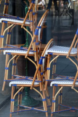 Kapalı bir restoranın vitrininde sandalyeler üst üste dizilmiş.