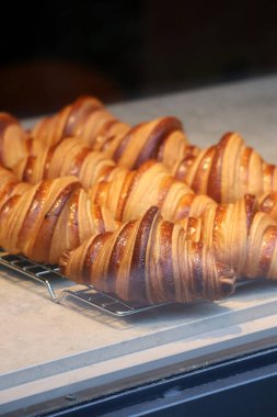 Bir pastanenin vitrininde taze ve güzel kruvasanların yakın çekimi.