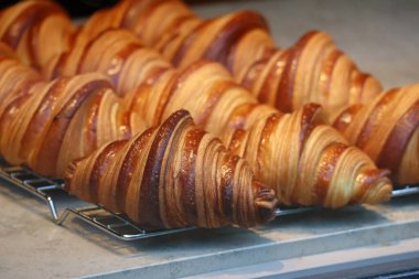 Bir pastanenin vitrininde taze ve güzel kruvasanların yakın çekimi.