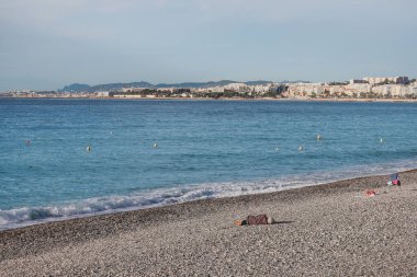 Güzel, Fransa - 29.09.2022: Bir adam Nice sahilinde uyur, sabah güneşinde