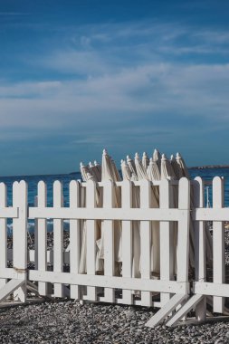 Mevsimin sonunda, sabah plajda kapalı güneş şemsiyeleri.