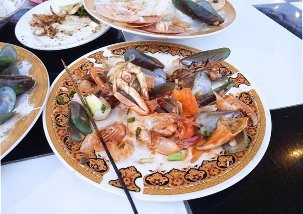 Doymak bilmeden deniz ürünleri yiyen ve sadece midye ve kirli deniz ürünleri tabakları bırakan bir turist.