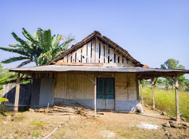 an old wooden house in the fields, a simple wooden house that is no longer inhabited and the dusty dirt yard
