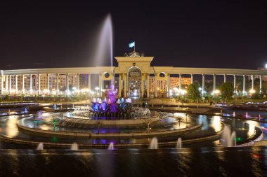 Kazakistan. Almaty şehrindeki ilk başkanın parkı. İyi akşamlar. Aydınlatılmış çeşmeler
