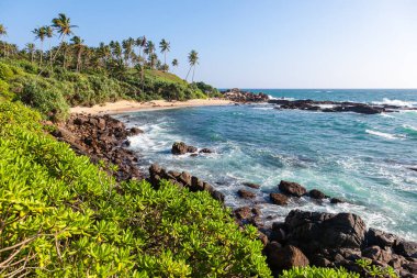 Turquoise waves crash on the sandy shore of the Indian Ocean. Mirissa. Malima. Sri Lanka. Vacation time