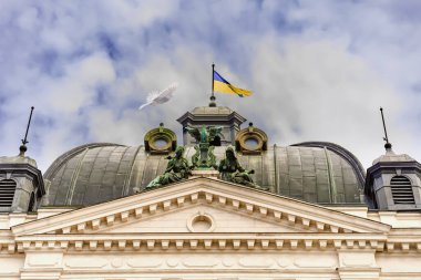 Lviv, Ukrayna - 18 Ağustos 2021 Ukrayna bayrağının tepesinde güzel bir güvercin uçuyor.