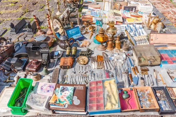 Lviv, Ukraine - August 18, 2021: Metal kitchen utensils, samovars, old vintage household items and books at a flea market.