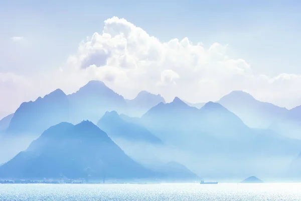 A soft focus view of mountains and blue water on Mediterranean sea