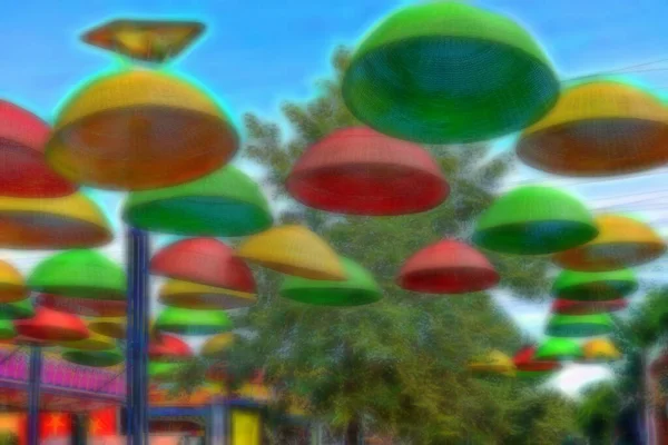 There are umbrellas hanging over the park alley. Against the background of the blue sky, umbrellas with colorful autumn colors. Colorful picture.
