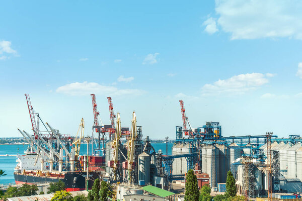 Cargo ship at the dock. Cranes and colored containers at the port.