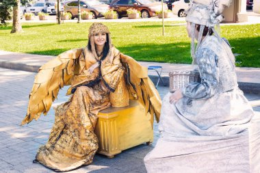 Odessa, Ukrayna - 17 Ağustos 2021: Altın rengi bir kadın kostümü giymiş güzel bir kız. Altın kanatlı yaratıcı seksi kıyafetler.