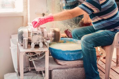 Eldiven ustası atölyede çalışıyor, taş oymacılığında. Ayarlanmış