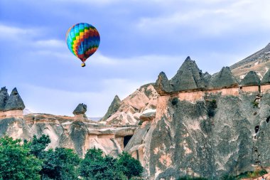 Kapadokya dağları üzerinde çok renkli balonlar uçuşuyor. Kapadokya kanyonunda kumtaşının sihirli formları,