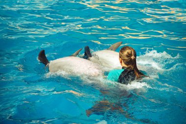 Mutlu kız yunuslarla geziyor. Sağlıklı yaşam tarzı
