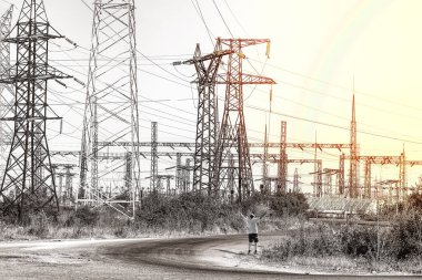 Adam elini kaldırdı ve güneşin doğuşuyla yüksek voltaj direğinde, elektrik direkleri kulelerinde karşılaştı. Elektrik dağıtım istasyonu. Elektrik santrali