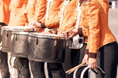 Güneşli bir günde davullu süvari üniformalı kızlar.