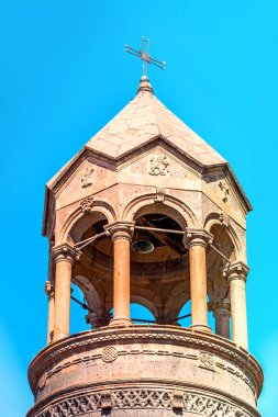 Oshakan köyündeki St. Mesrop Mashtots Kilisesi 'nin yüksek silindirik çan kulesi bulutlu bir bahar gökyüzünün arka planı.