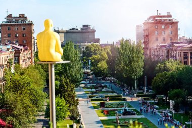 YEREVAN, ARMENIA - 23 Temmuz 2018: Cascade Modern Sanat Merkezi Müzesi kompleksinden güneşli bir günde Erivan manzarası ve ön planda oturan bir adamın heykeli