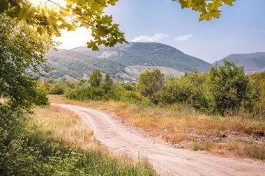 Boş yol altında günbatımı gökyüzü güneş ışınları ile kırsal manzara geçmekte. kuru mevsim Güneydoğu Asya, myanmar (burma). doğa arka planda vintage tarzı