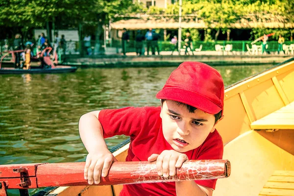 Kırmızı Tişörtlü Beysbol Şapkalı Bir Çocuk Tekneye Binip Kürek Çekiyor — Stok fotoğraf