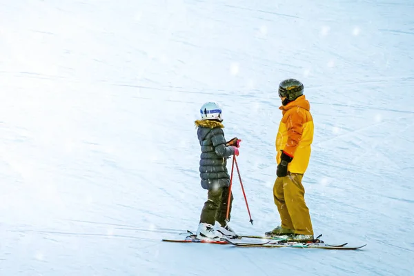 Couple in love, skiers, stand in the snow and look at each other