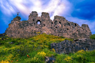 The man stands on ruins  of Amberd Fortress and raised his hands up . Armenia